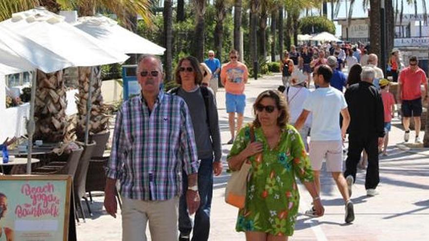 Turistas disfrutan del paseo marítimo de Marbella.