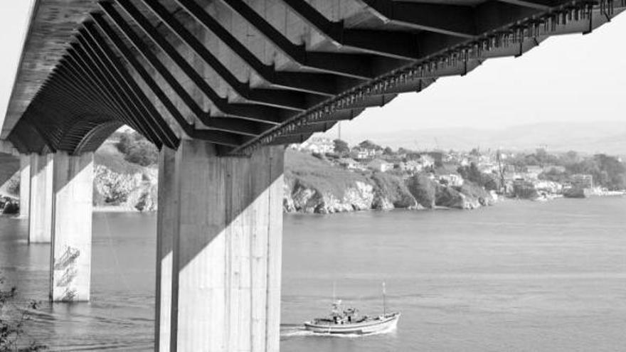 Un pesquero cruza bajo el puente de los Santos, en la ría del Eo.