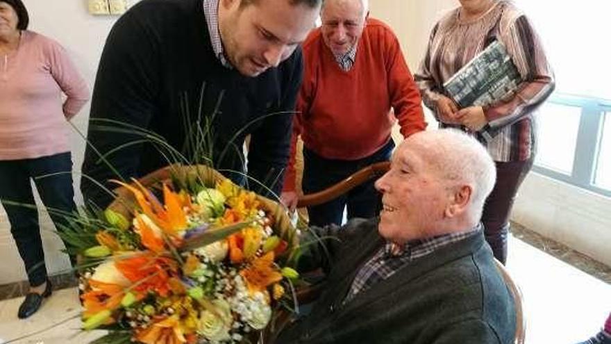 Cubela, entregándole un ramo de flores al nuevo centenario.