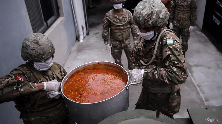 Soldados argentinos reparten alimentos a pobladores de barrios de bajos recursos.