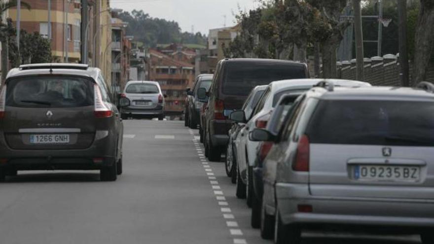 Coches circulando por una céntrica calle de Luanco.