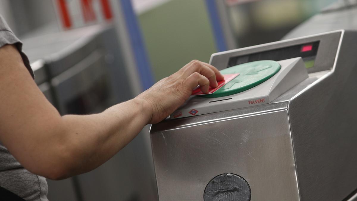 Una persona pasa su billete en un torno del Metro de Madrid.