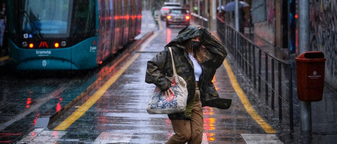 Una mujer huye de las fuertes lluvias en Santa Cruz de Tenerife.