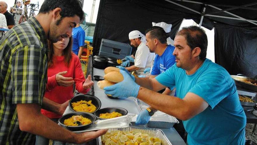 Francisco Javier Martínez, en primer término, repartiendo paella en Muncó