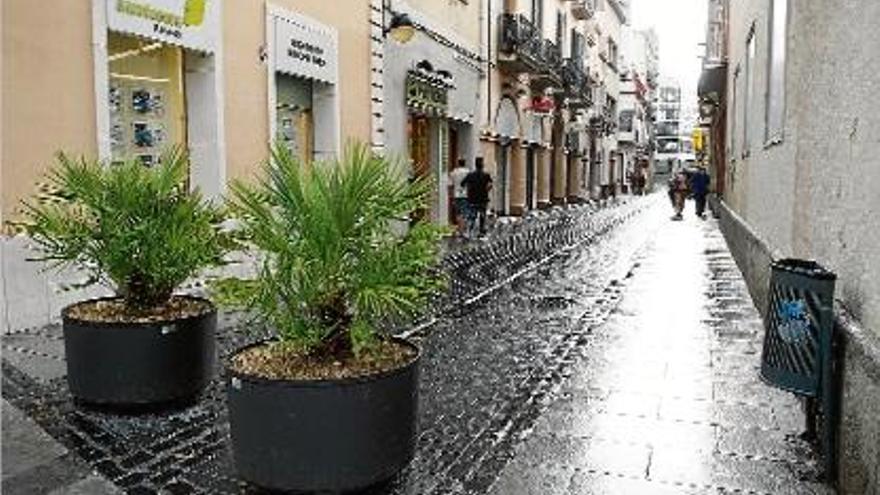 El carrer Concepció de Figueres tancat per dues jardineres en ple estiu.