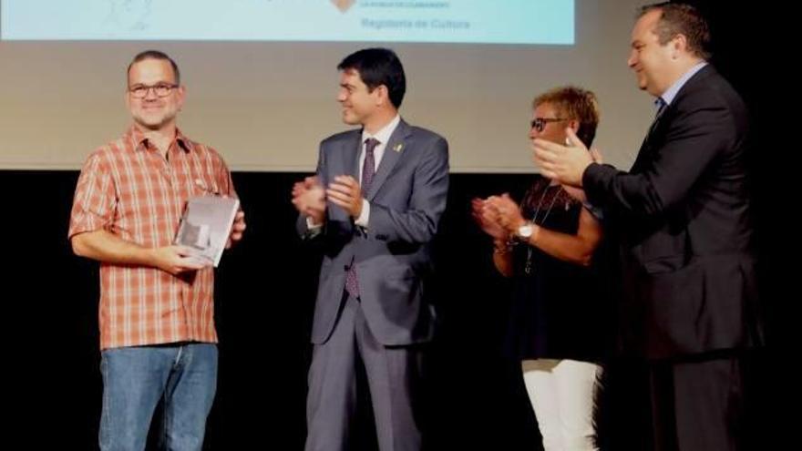 Jordi Gibert en el moment de rebre el premi de mans del president de la Diputació, Marc Castells