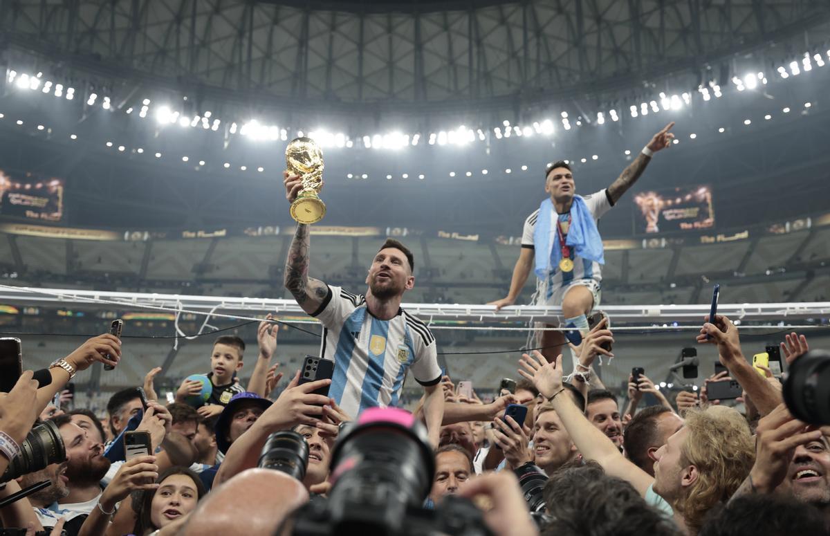 Messi enseña el trofeo de campeón del mundo, mientras da la vuelta de honor a hombros de sus compañeros