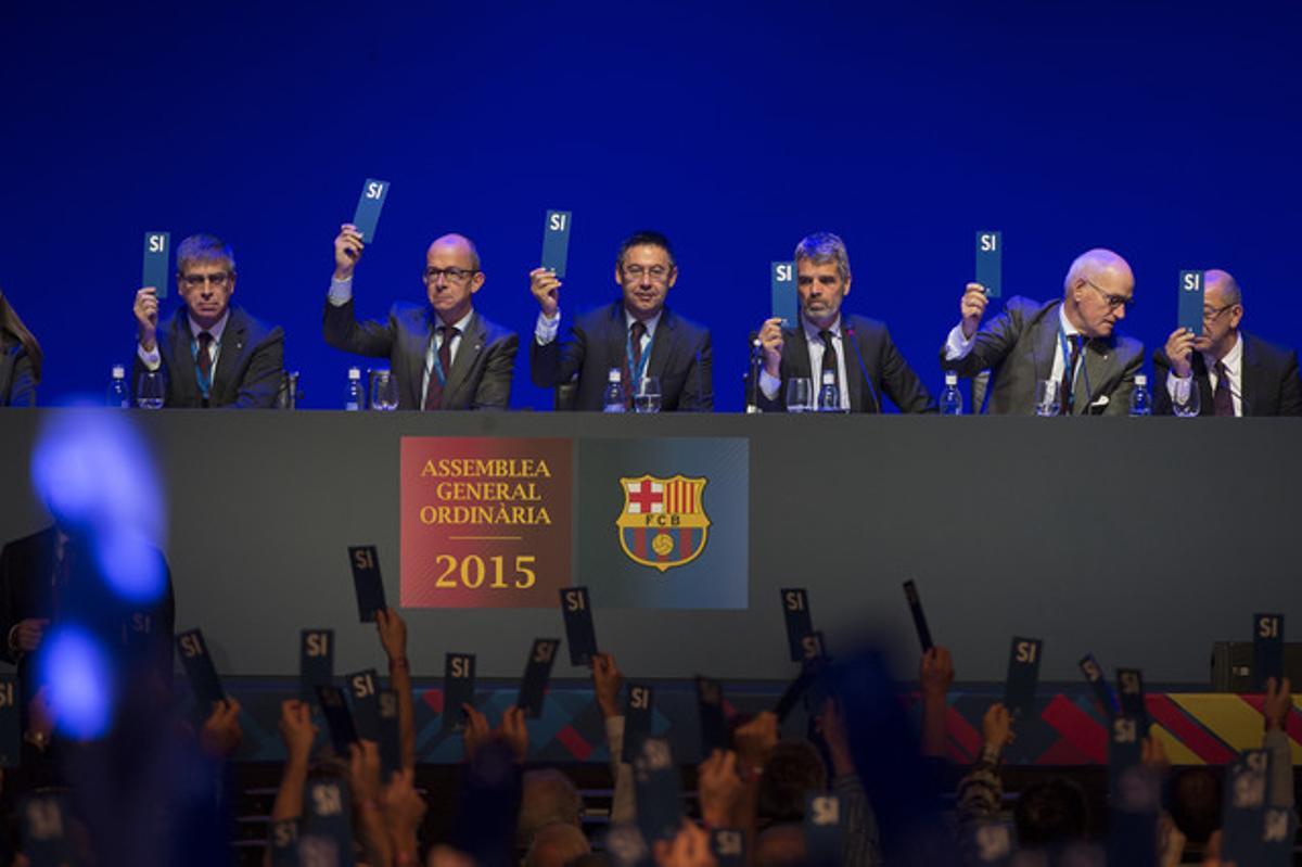 El president del FC Barcelona, la seva junta directiva i els compromissaris aixequen la seva cartolina amb el ’sí’ aprovant la liquidació de l’exercici econòmic durant l’assemblea general ordinària 2015.