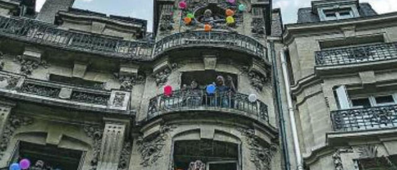 Residentes en París bailan en sus balcones con la actuación de un DJ.