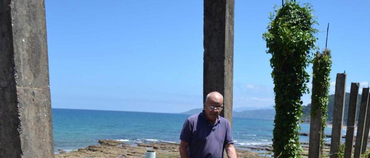 Ángel Moro, junto a las ruinas del hotel, en la playa del Astilleru.