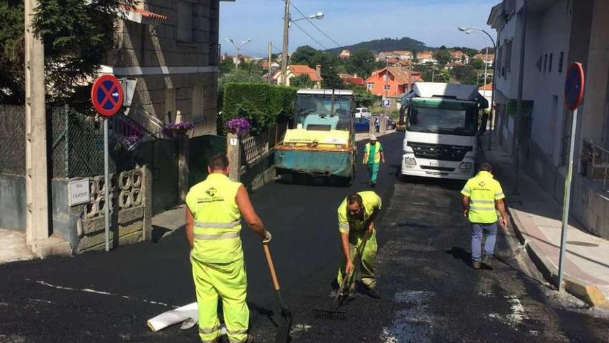 Operarios renuevan la capa de asfalto de la calle Vilameán, en el casco urbano nigranés.  // FdV