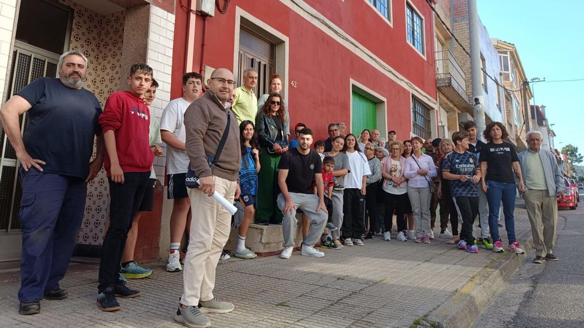 Un grupo de afectados, ayer, ante una de las casas 
de la Avenida de Vigo cuyos propietarios rechazan el
 paso de los cables de fibra óptica por su fachada.   | // A.P.