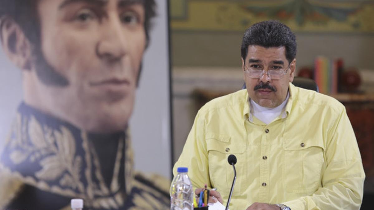 Handout photo of Venezuela's President Nicolas Maduro speaking next to an image of South American El presidente venezolano Nicolás Maduro.