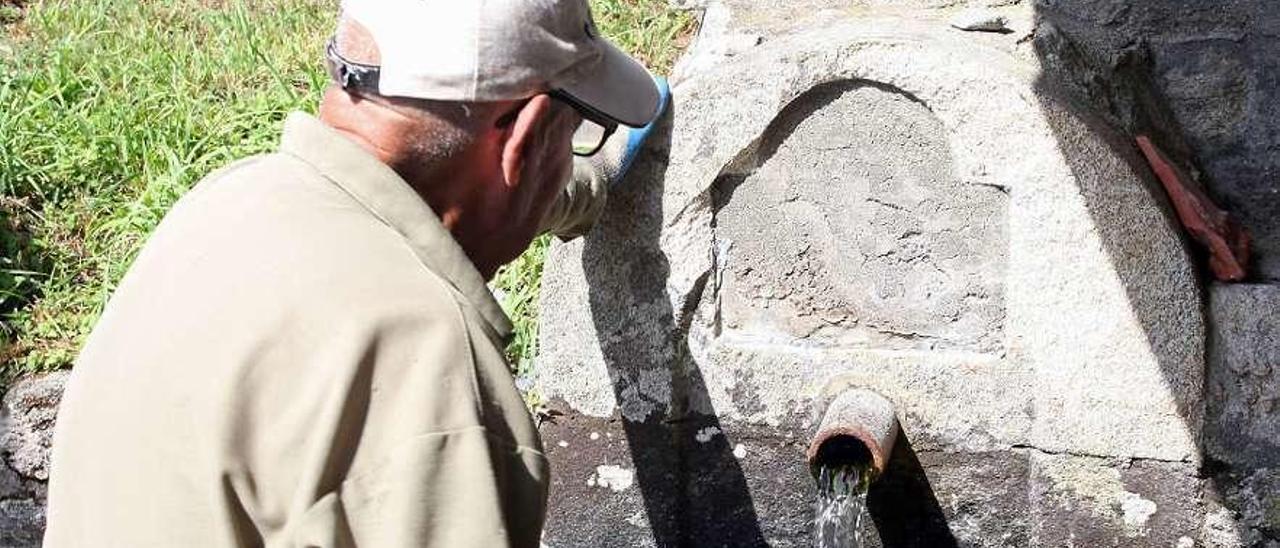 Un vecino contempla el hueco y la piedra afectada por la retirada de esta placa. // Bernabé/Juan Carlos Asorey