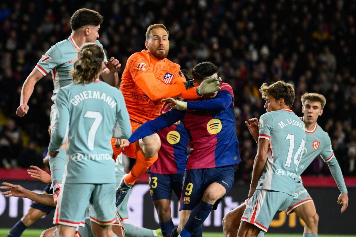 Jan Oblak golpea a Robert Lewandowski en el partido del sábado.