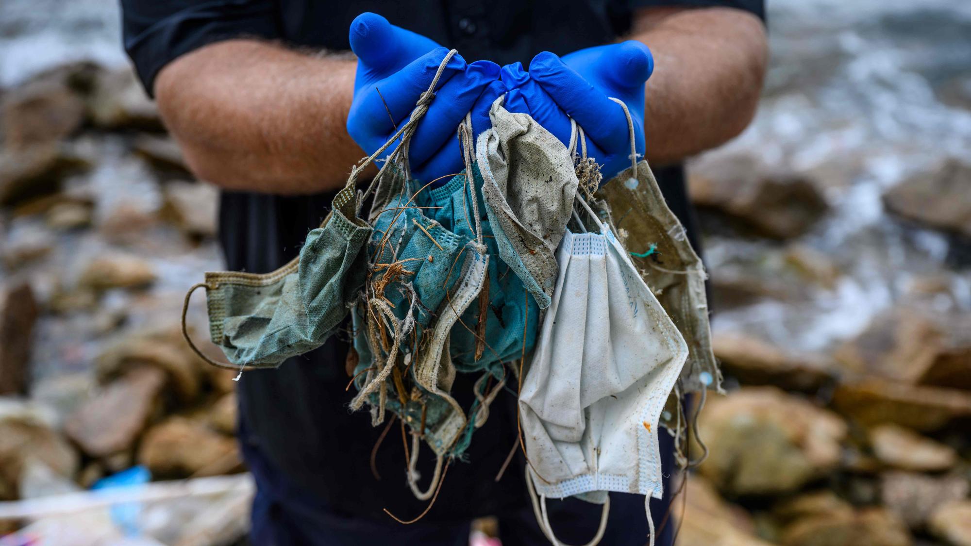 Plásticos y mascarillas en el mar, vergüenza pos-Covid-19. In this photo taken on May 13, 2020, Gary Stokes, founder of the environmental group Oceans Asia, poses with discarded face masks he found on a beach in the residential area of Discovery Bay on the outlying Lantau island in Hong Kong. - Surgical masks are washing up in growing quantities on the shores of Hong Kong, a city that has overwhelmingly embraced face coverings to fight the coronavirus. Conservationists say the masks are adding to already alarmingly high levels of plastic waste in the waters around the finance hub. (Photo by Anthony WALLACE / AFP). FOTO SIN DERECHOS DE REPRODUCCION