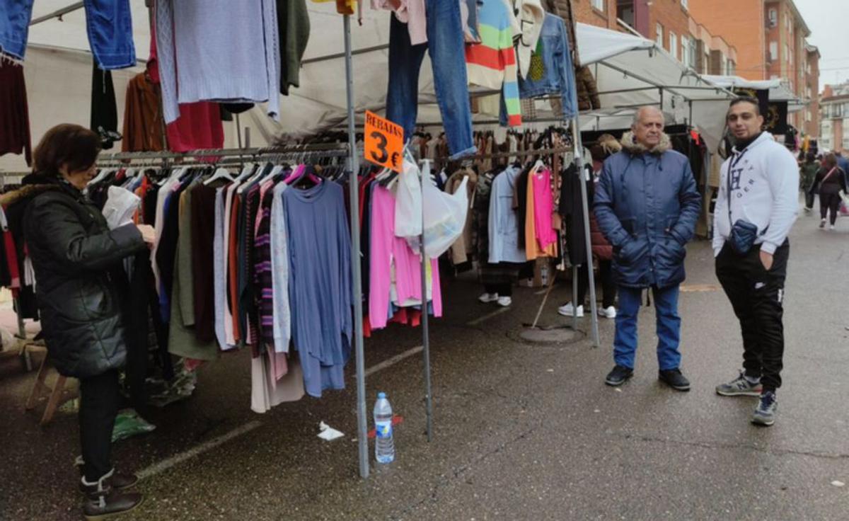 Vendedores y visitantes del mercadillo de la ropa. | E. P.