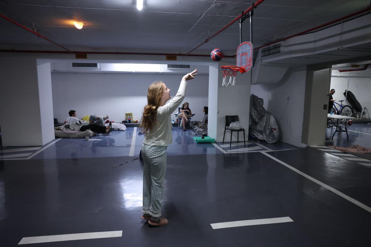 Una niña juega a baloncesto en un refugio antiaéreo durante una alerta por lanzamiento de misiles de Irán, en Tel Aviv.