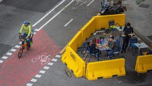 Una terraza de restaurante ampliada en la calzada a partir de barreras New Jersey pintadas de amarillo. 