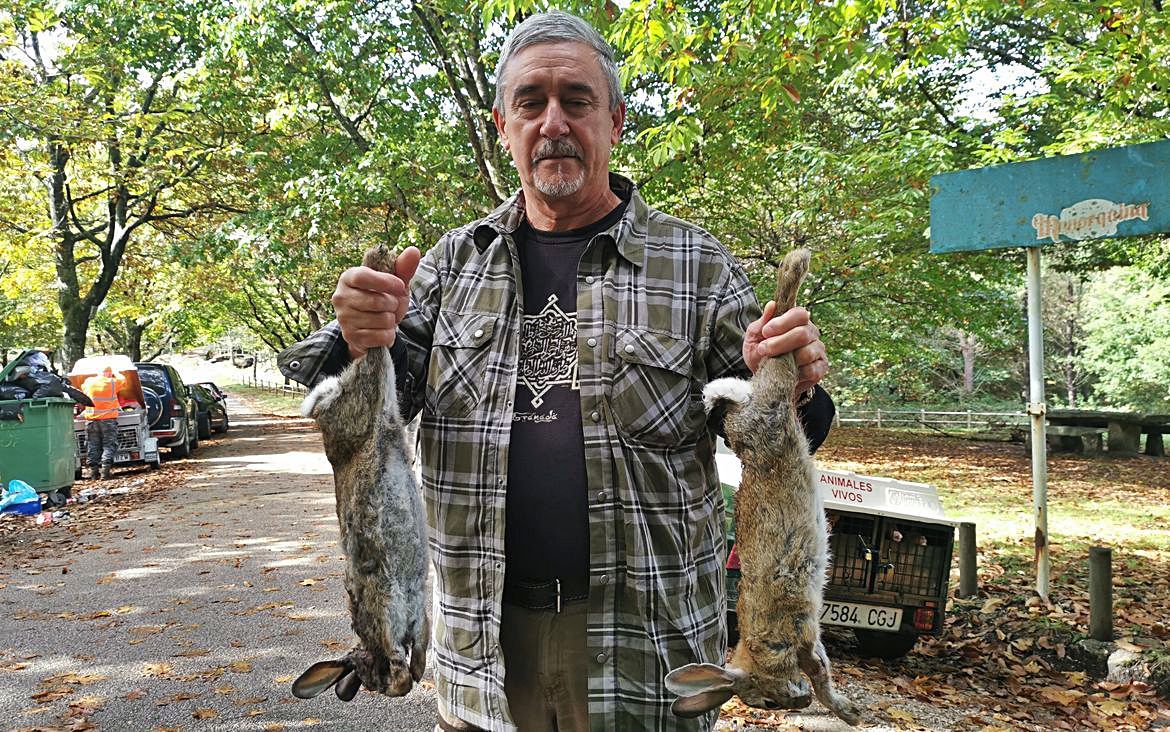 Un cazador muestra dos conejos capturados.   | // SANTOS ÁLVAREZ