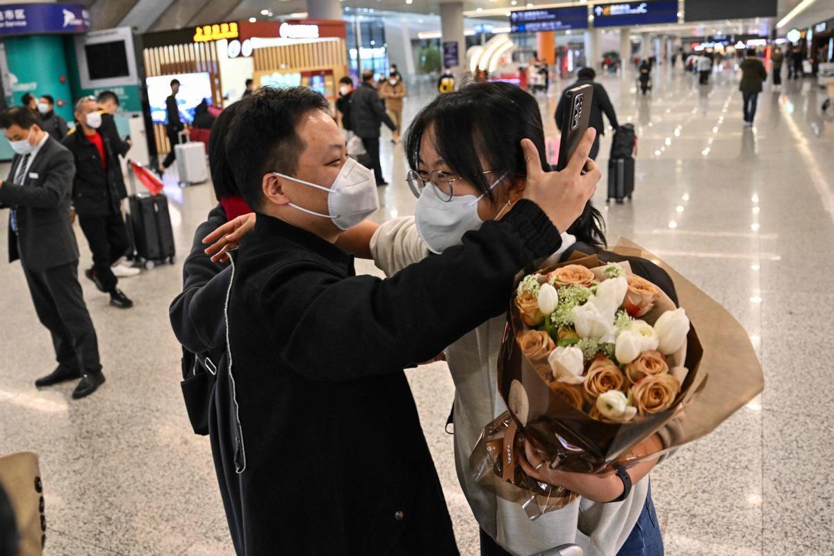 Un pasajero recibe un abrazo al salir del área de llegada de vuelos internacionales en el Aeropuerto Internacional de Shanghai Pudong.