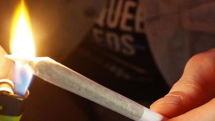 Un joven se dispone a encender un porro.