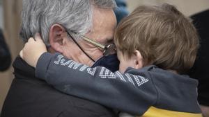 Un nieto sonríe con su nieto en brazos.