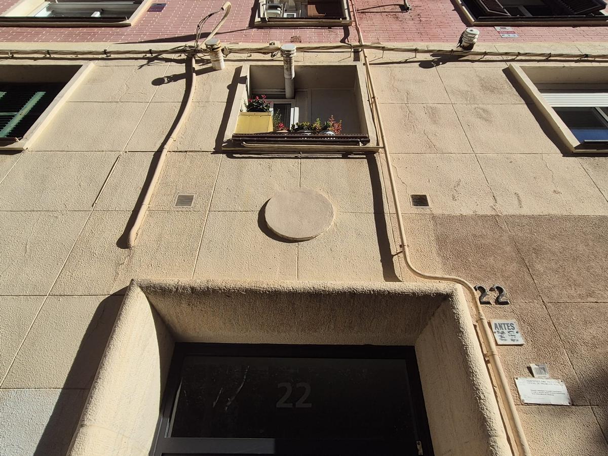 Un escudo de la franquista Obra Sindical del Hogar, tapado sobre un portal del distrito de Sant Martí, en Barcelona.