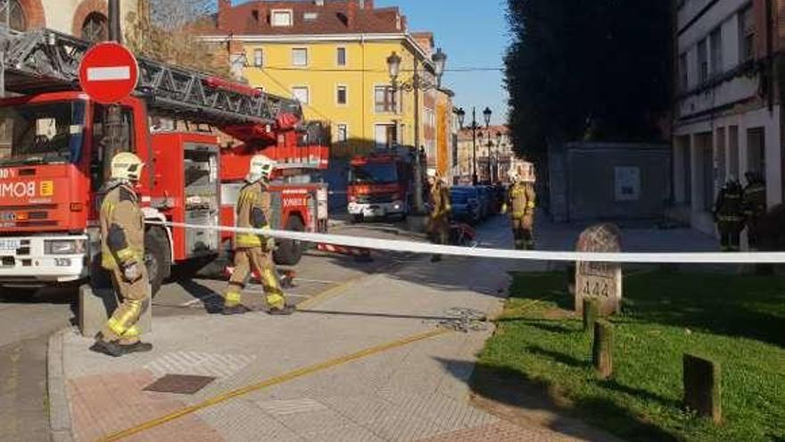 Bomberos acordonan el edificio durante las labores de extinción.