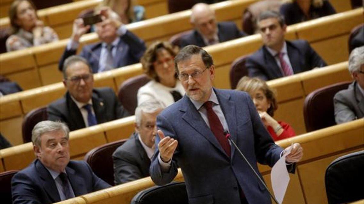 El presidente del Gobierno, Mariano Rajoy, habla desde su escaño en el pleno del Senado.