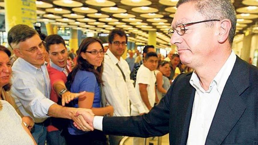 Gallardón es saludado por diversas personas a su llegada al aeropuerto de Barajas. // Efe