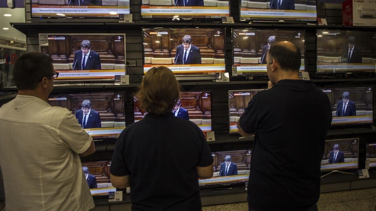Discurso de Puigdemont sobre la DUI en el Parlament, seguido por las pantallas de una tienda de electrodomésticos, el 10 de octubre del 2017.