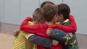 Abraçada entre un grup dalumnes deducació infantil.