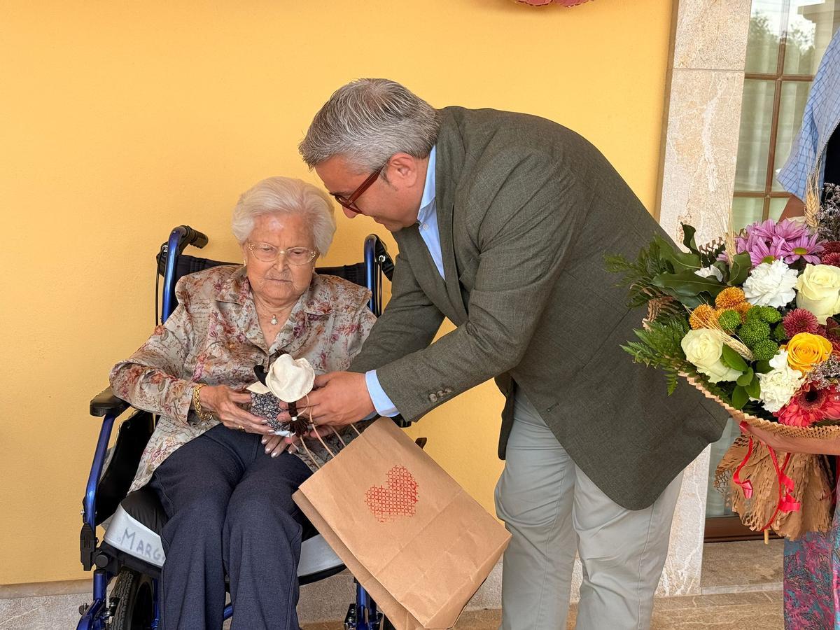El alcalde Virgilio Moreno entrega un obsequio a la vecina centenaria.