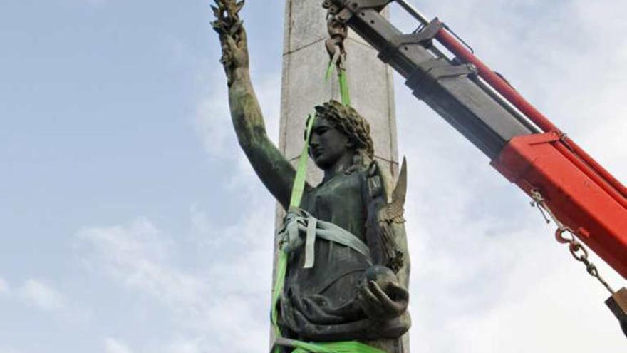 Una grúa retira la estatua de la Victoria ayer en Barcelona.