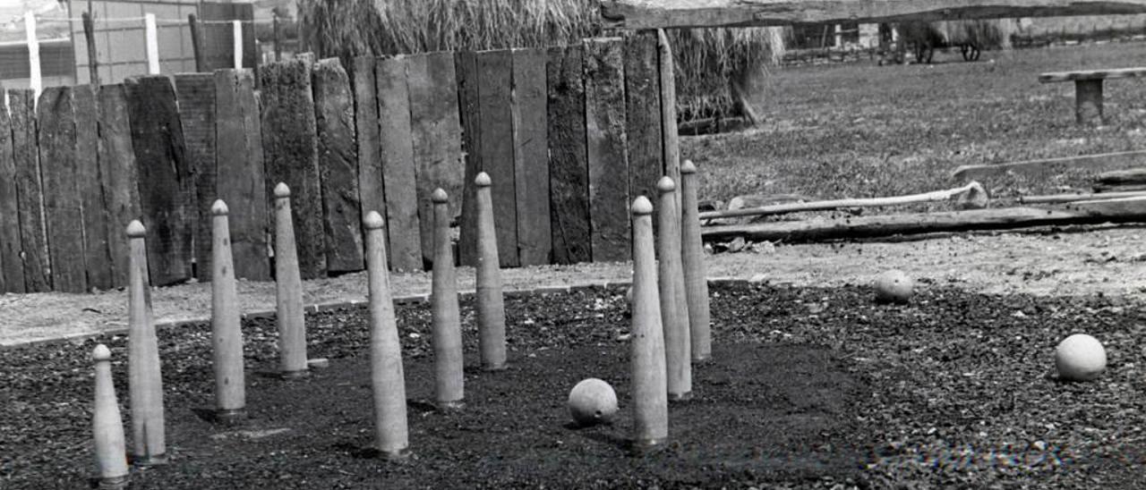 Fotografía histórica de un castro con los nueve bolos y el biche para jugar a la modalidad de cuatreada, en el recinto del Museo del Pueblo de Asturias.