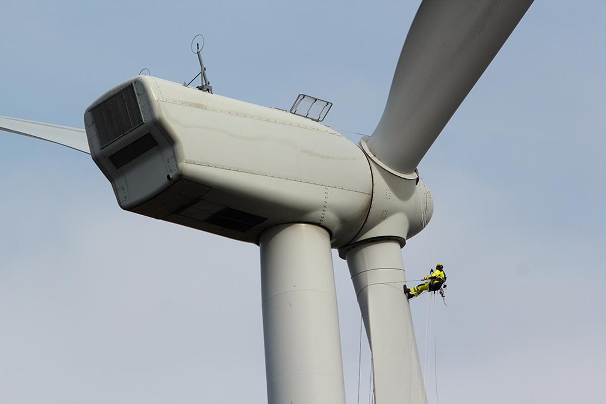 Un operario trabaja en un aerogenerador de energía eólica.