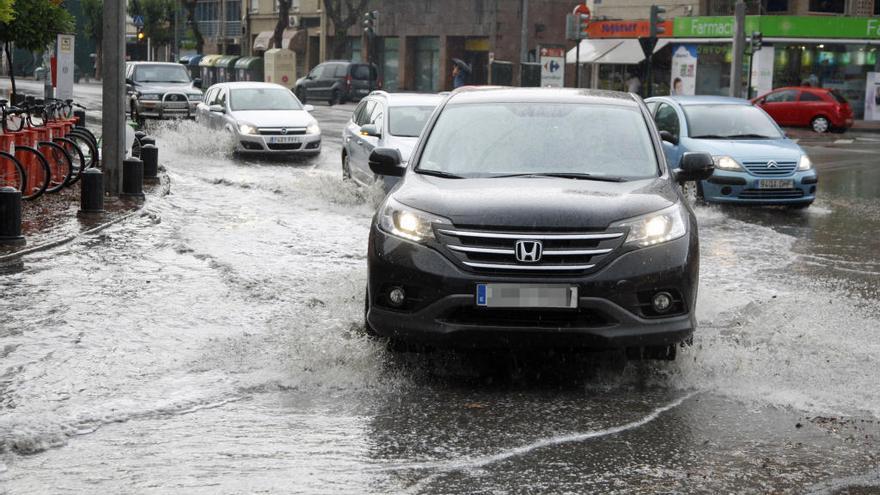 La lluvia obstaculiza el tráfico en el centro de Murcia.