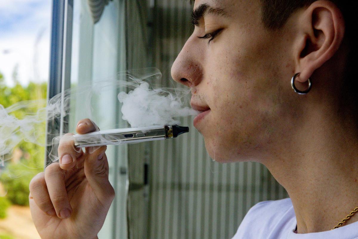 Un joven vapeando.