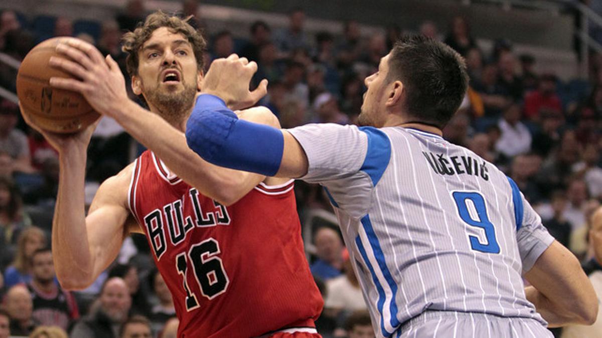 Pau Gasol trata de pasar el balón ante la defensa de Nikola Vucevic, en el partido entre los Bulls y los Magic