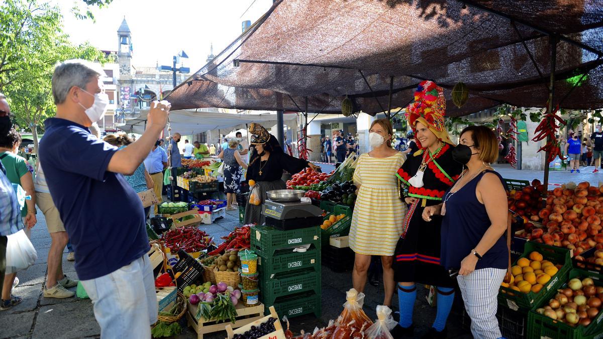 Una familia se retrata ayer en el mercado junto a una joven con el traje de montehermoseña.