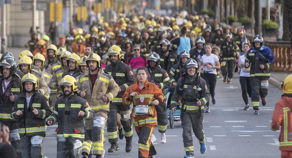 El grupo de bomberos participantes en el primer km de carrera a su paso por Colón.