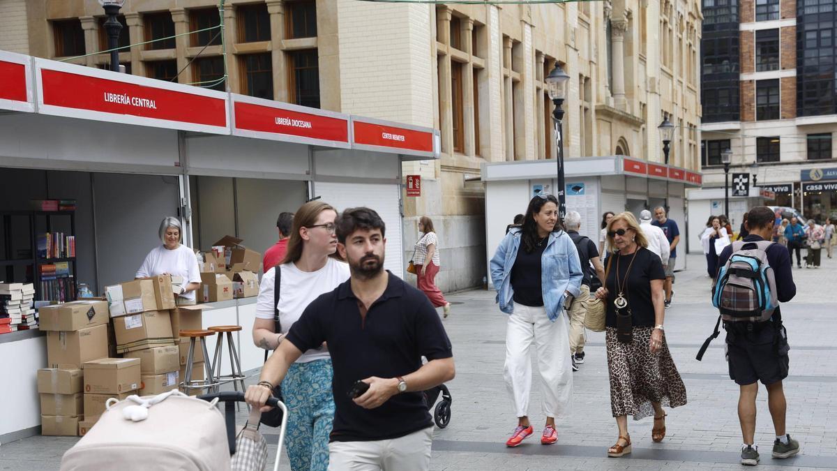 Libreros montando sus casetas en la Feria del Libro de Gijón, este martes.
