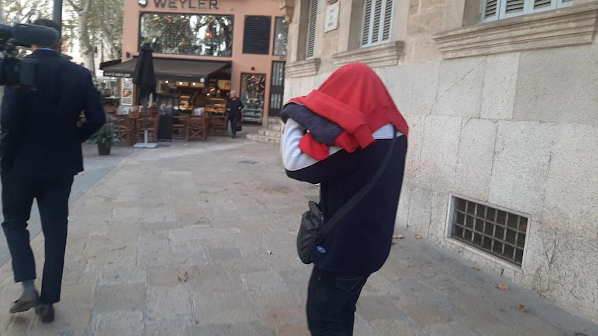 El padre acusado de abusar de sus hijos, se tapa la cara con una chaqueta roja al salir de la Audiencia.