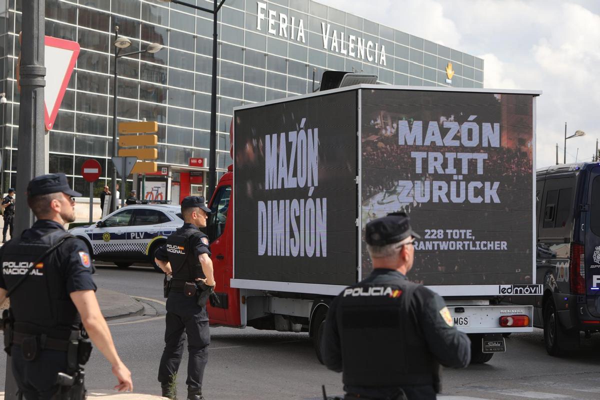 Un camión se pasea con paneles pidiendo la dimisión de Mazón en varios idiomas.