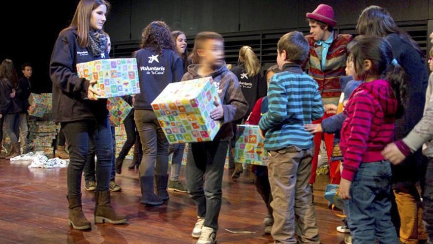 Imagen de los niños mientras recogen sus regalos.