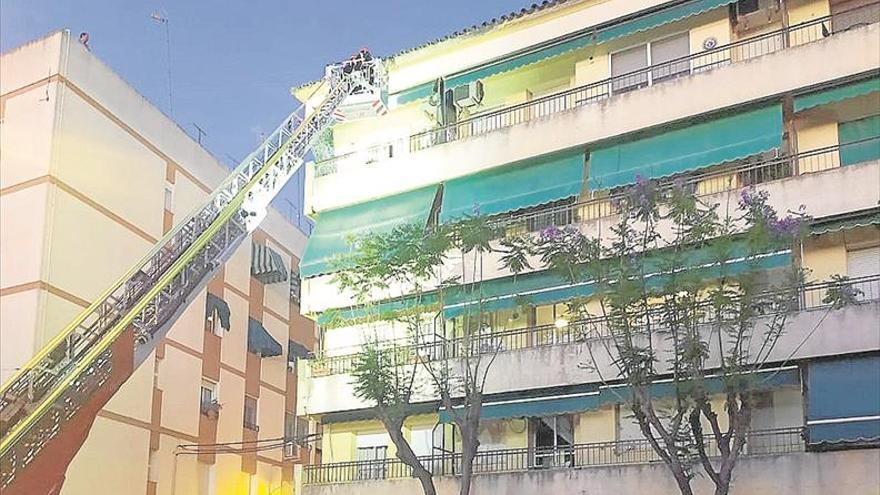 Los bomberos desmontan la cornisa de un edificio de la Avenida de la Constitución