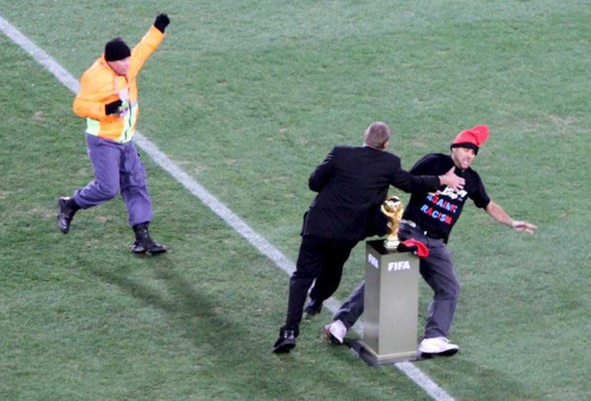 Un guàrdia de seguretat atura Jimmy Jump quan intentava agafar el trofeu per col·locar-li una barretina. Un guàrdia de seguretat atura Jimmy Jump quan intentava agafar el trofeu per col·locar-li una barretina.