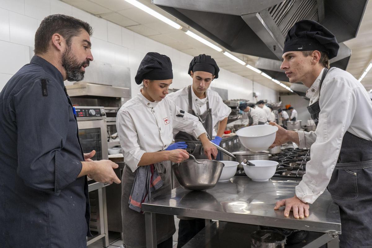 Oriol Margalef, professor de cuina de la Joviat, acompanyat dels alumnes de tercer curs del grau mitjà de cuina i gastronomia, Biel Jaramillo, Àuria Espelt i Mateu Torra