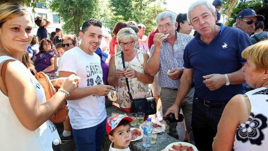 Varios comensales degustan jamón en la Carballeira de Cacharado. // A. Hernández